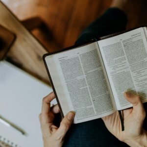 a person holding an open book in their hands